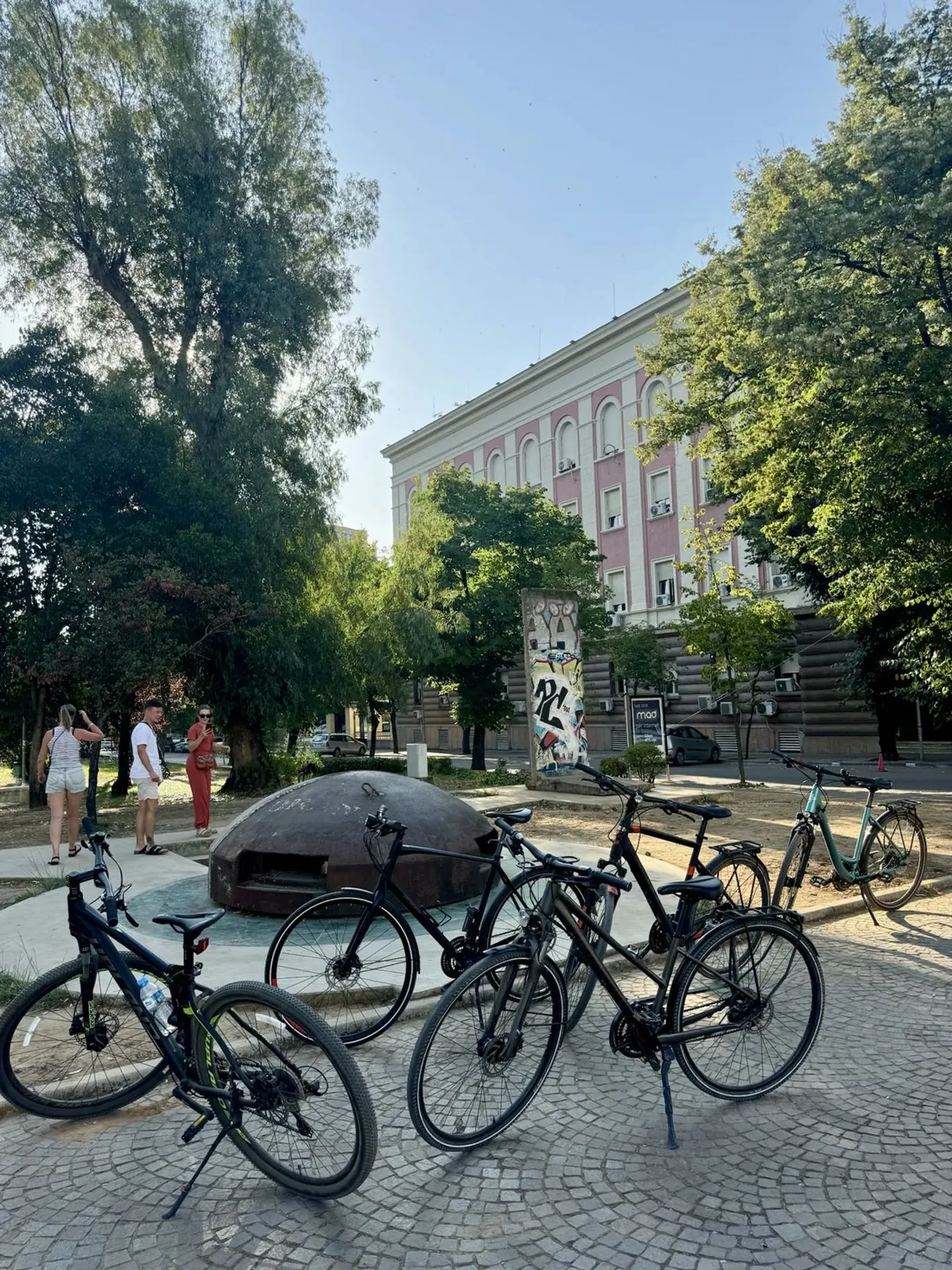 Meerdere fietsen geparkeerd op een geplaveid plein met historische gebouwen op de achtergrond